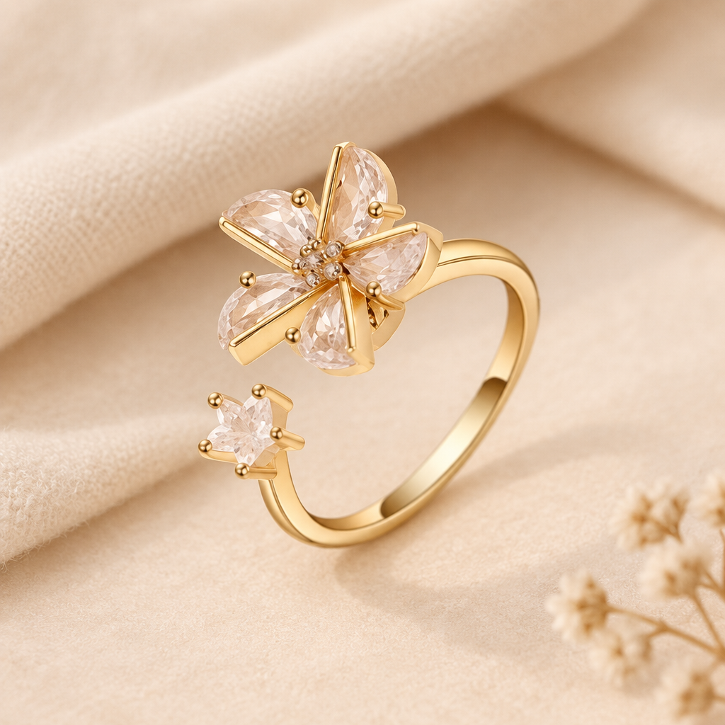 Bague au fini doré ornée d'un motif floral étoilé ivoire rosé, sur un fond ivoire doux avec tissu crème